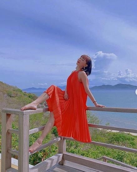 Mới đây, Tóc Tiên thả dáng trong chiếc đầm đỏ cổ yếm xếp li nổi bật trước sắc xanh của mây trời và cỏ cây.