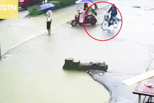 Clip: Cô gái đi xe đạp rơi vào hố nước sâu, bị 'nuốt chửng' giữa phố ở Trung Quốc