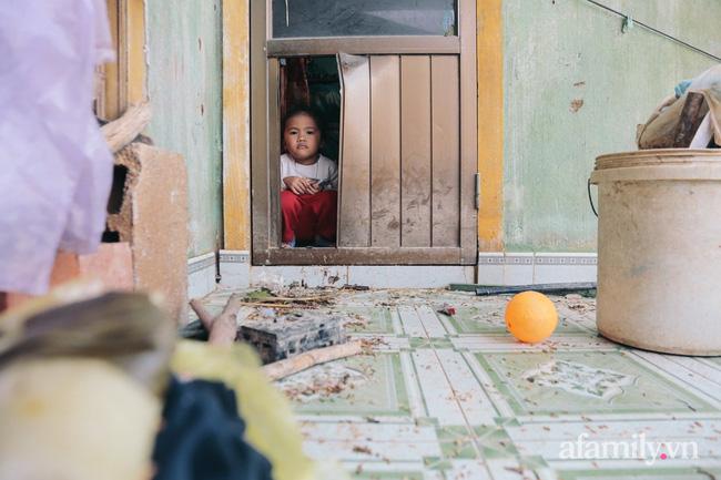 Cô bé ngồi trong nhà nhìn ra dòng nước lũ. Có thể cháu còn quá bé để hiểu hết những gì gia đình đã trải qua.