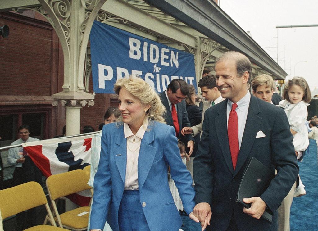 Tháng 6/1987, ông Joe Biden có khoảnh khắc tình cảm bên vợ sau khi tuyên bố tranh cử tổng thống ở Wilimington, Delaware, Mỹ. Ông xuất hiện với bộ suit được thiết kế vừa vặn. Mẫu cà vạt đỏ nổi bật khi được ông phối cùng trang phục tông trung tính. Ảnh: Associated Pres