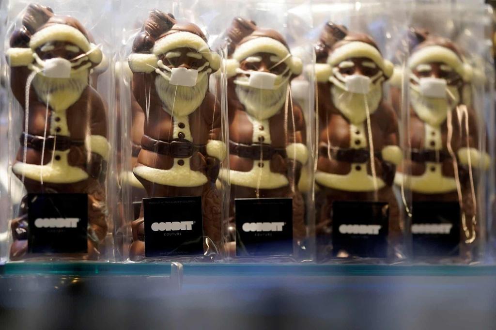 Những thanh chocolate hình ông già Noel nay lại có thêm một miếng khẩu trang vani trắng. Ảnh: Ronald Wittek/EPA.