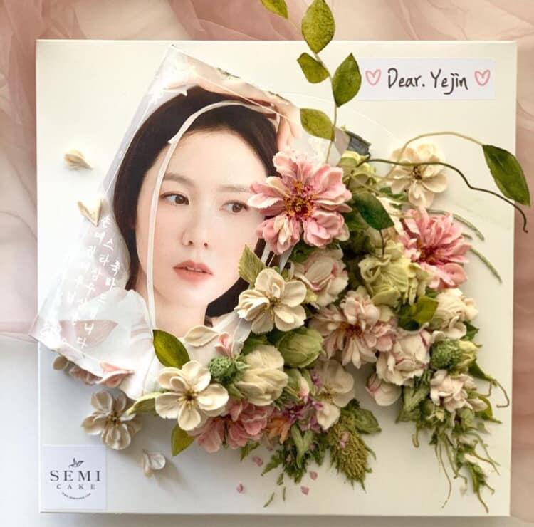 Mới đây, Son Ye Jin đã đăng tải lên mạng xã hội một chiếc bánh tạo kiểu hình hoa và khuôn mặt nữ diễn viên. Cùng với dòng chứ "Dear Yejin", nhiều người hâm mộ không khỏi tò mò phải chăng Hyun Bin là người đã gửi tặng món quà này. Trên thực tế, món quà độc đáo này được đặt bởi các fan của Son Ye Jin. Ngôi sao "Hạ cánh nơi anh" cũng chia sẻ: "Tôi chưa bao giờ nhìn thấy loại bánh hoa nào đẹp như vậy. Cảm ơn tất cả các bạn".