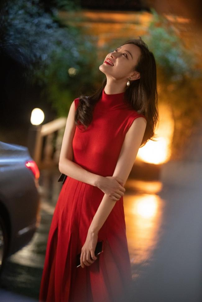 Chiếc váy đỏ và clutch của Givenchy, trong khi hoa tai của Gucci.