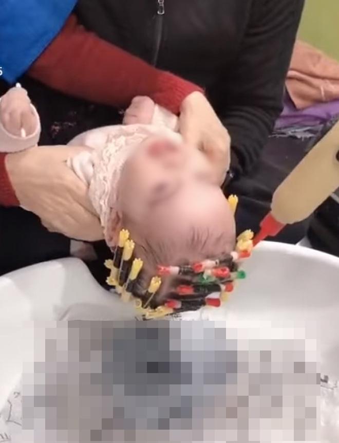 Phẫn nộ bà ghì chặt cháu 1 tuổi để thợ đổ hóa chất lên đầu làm tóc xoăn-1