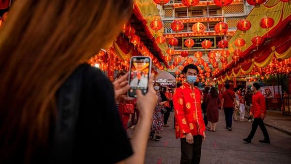 Một người đàn ông chụp ảnh cùng khẩu trang ở khu Chinatown tại Bangkok, Thái Lan hôm 11/2. Ảnh: Getty Images.