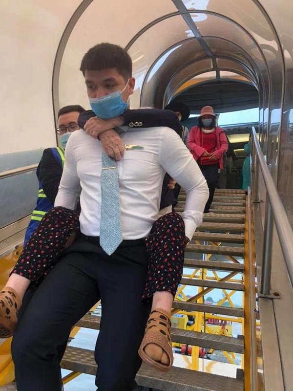Nam tiếp viên hàng không cõng bà cụ xuống thang máy bay nhận được lời khen-2