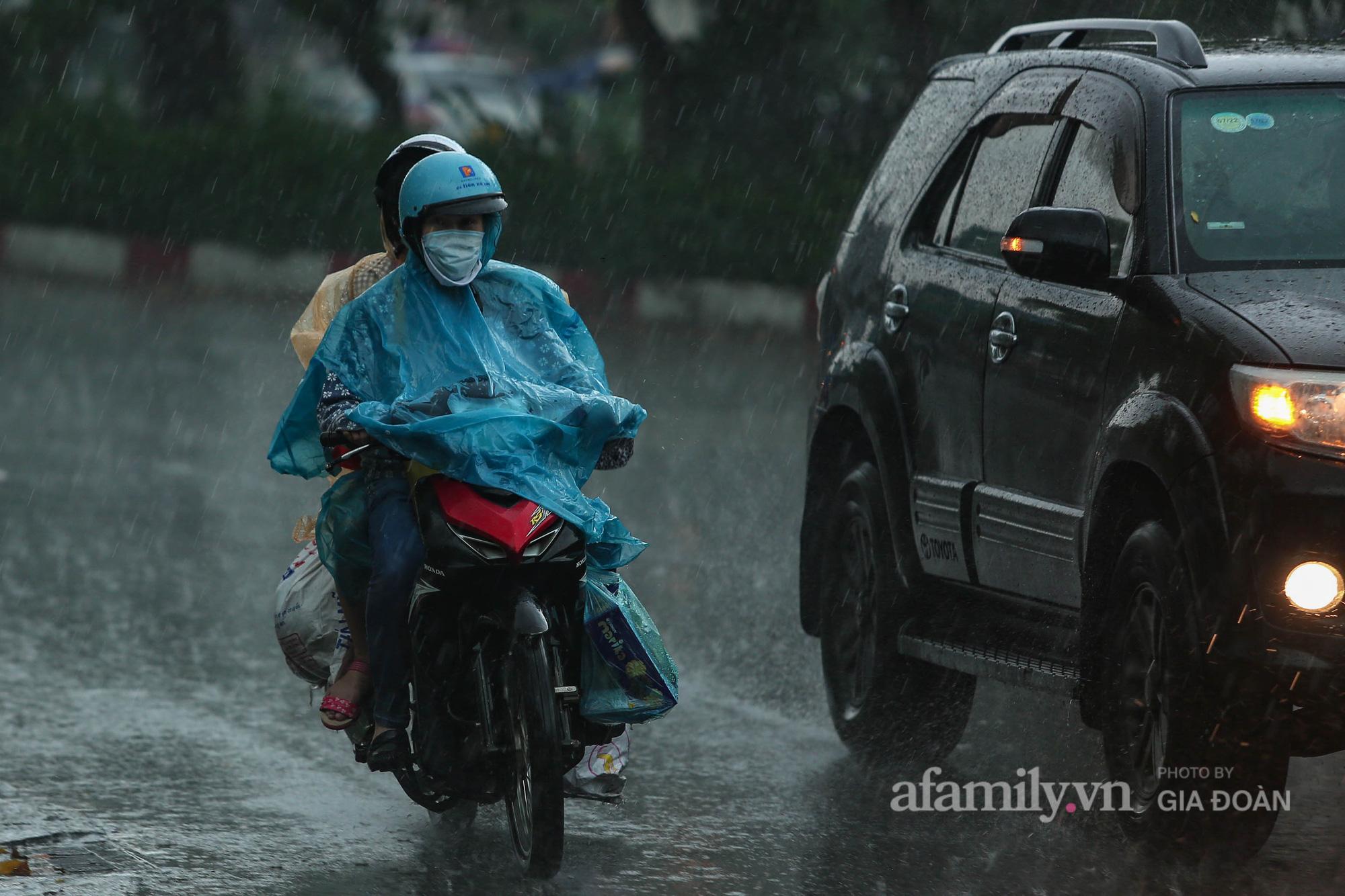 Trước trận mưa lớn, bầu trời Hà Nội kéo mây đen nhờ đó người dân đã có sự chuẩn bị áo mưa cho khỏi ướt.