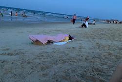 Đang ở giữa bãi biển, cô nàng thản nhiên nằm xuống bãi cát làm chuyện ái ngại