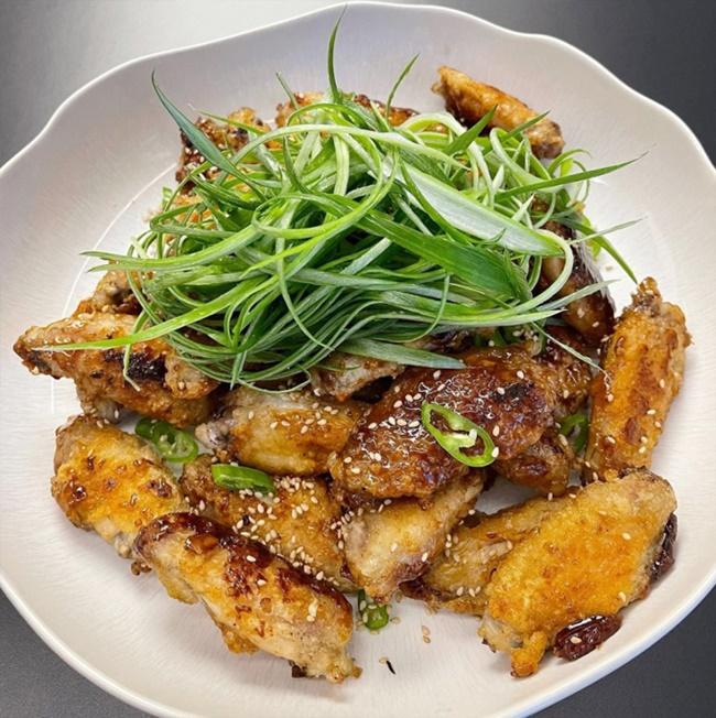 Nhân ngày chủ nhật rảnh rỗi, Son Ye Jin lại vào bếp làm cánh gà sốt xì dầu - một món ăn khác rất quen thuộc trên mâm cơm của người Hàn. Gà được ướp một lớp gia vị và bột mỏng bên ngoài, đem chiên giòn, sau đó được sốt cùng xì dầu, đường, tiêu, giấm, rượu nấu ăn... Cuối cùng, bạn gái Hyun Bin rắc thêm chút vừng cho thơm và cho thật nhiều hành lá chẻ dọc. Thịt gà chiên thơm nức mũi, lớp vỏ giòn, nước sốt đậm đà, ngọt cay hấp dẫn, ăn kèm kim chi hoặc củ cải muối thì rất hao cơm.