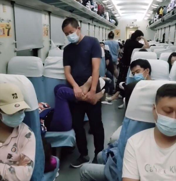 Chồng đứng ôm chân giúp cho vợ ngủ cả đêm trên tàu lửa-1