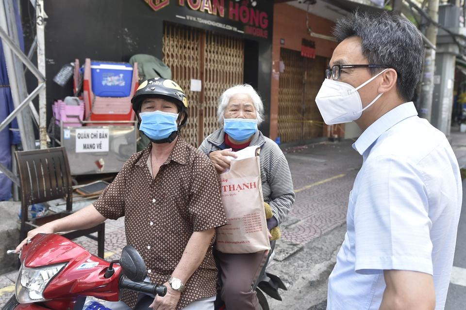 Phó thủ tướng hỏi thăm một cụ bà được người thân chở trên đường. Cụ bà cho biết bị cao huyết áp, được em trai đưa đi khám, lấy thuốc uống hàng ngày.