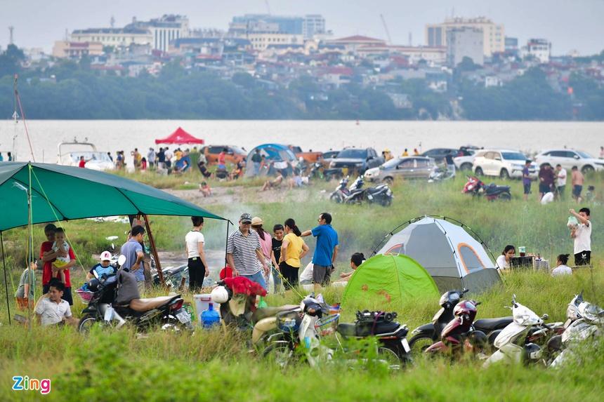 Chiều 3/10, rất đông người đổ về bãi đất trống gần chân cầu Vĩnh Tuy vui chơi, hóng mát. Họ mang theo lều trại và dựng san sát nhau. Trước đó, theo quy định của thành phố kể từ ngày 28/9, người dân được thể dục, thể thao ngoài trời nhưng không tập trung quá 10 người.