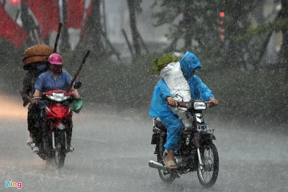 Trận mưa lớn kèm theo gió mạnh xuất hiện lúc 16h30 tại nhiều quận, huyện Hà Nội khiến người đi xe máy gặp khó khăn trên đường đi làm về. Hình ảnh tại phố Tân Mai (quận Hoàng Mai). Ảnh: Việt Linh.