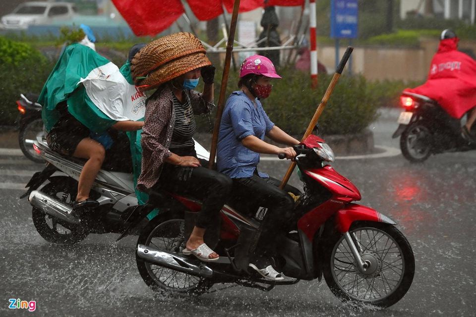 Nhiều người không trú mưa, vẫn cố gắng phóng xe máy về phía trước. Ảnh: Việt Linh.