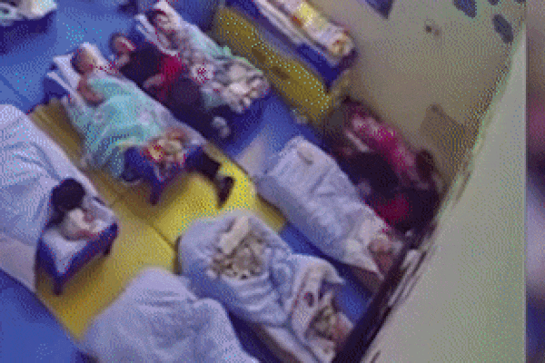 Cô giáo mầm non dùng băng dính quấn trẻ vào chăn, làm gối gác chân-1