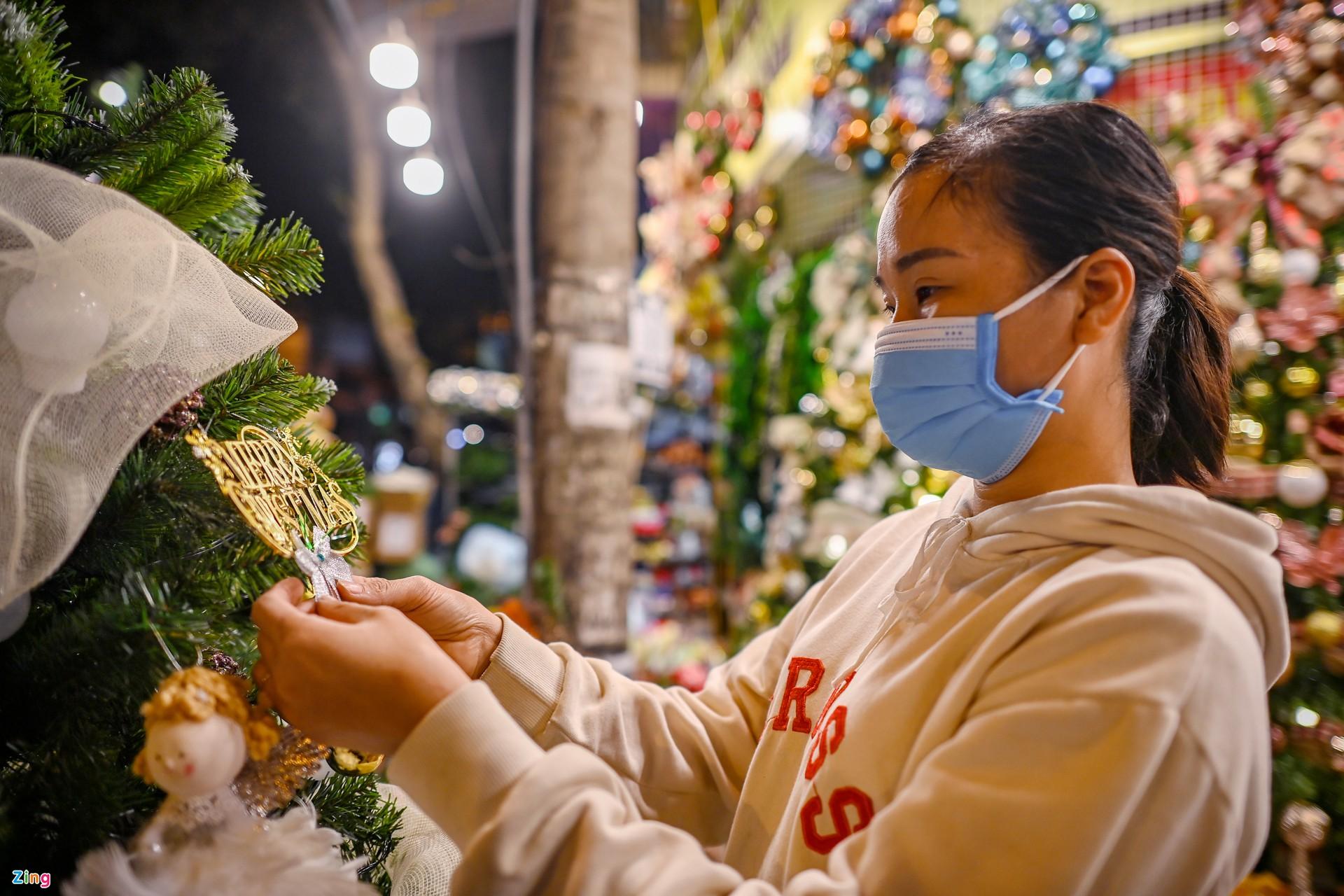 Nhân viên một cửa hàng trên phố Hàng Mã tất bật giới thiệu những mặt hàng trang trí mẫu mã mới được nhiều người lựa chọn năm nay.