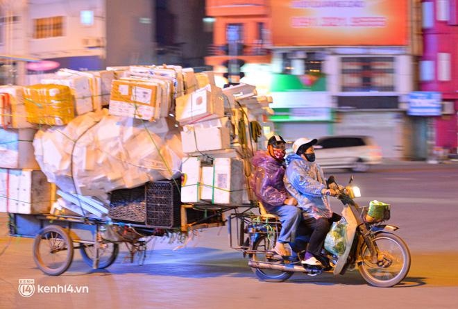 Những người thu gom phế thải mặc thêm áo mưa để làm việc về đêm