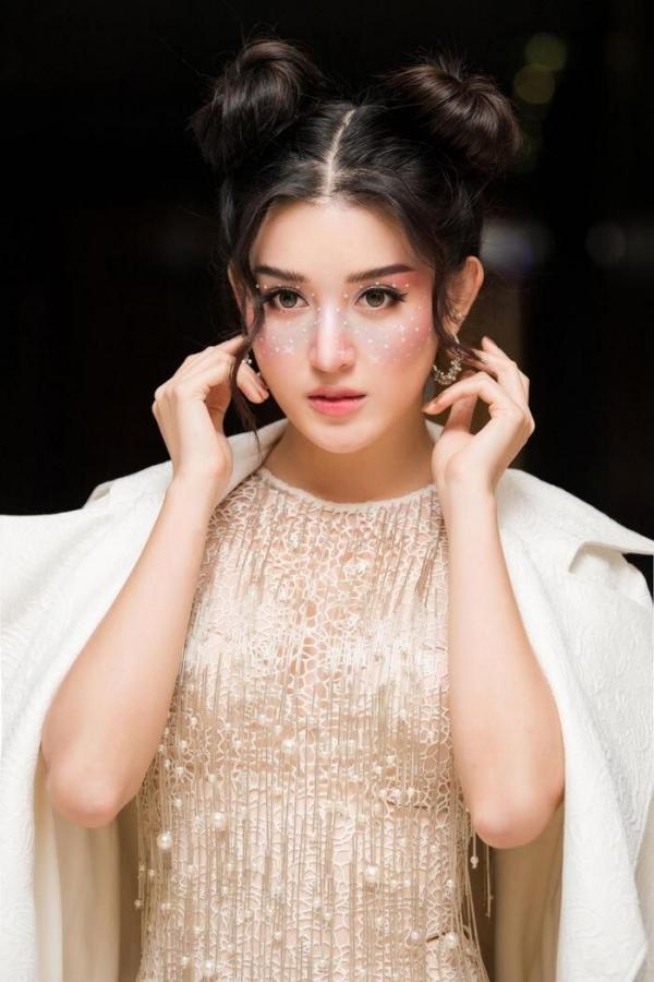 Huyền My hóa nữ thần ngọt ngào với tóc búi Na Tra, cô tạo nét cuốn hút cho gương mặt bằng mái uốn xoăn lọn.
