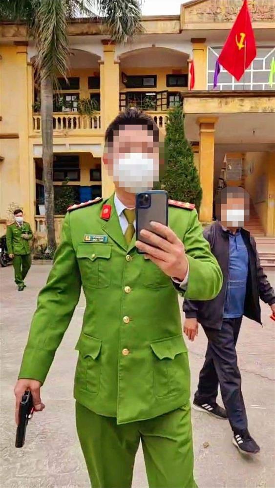 Công an 1 tay cầm điện thoại, 1 tay cầm súng nói chuyện với dân-1