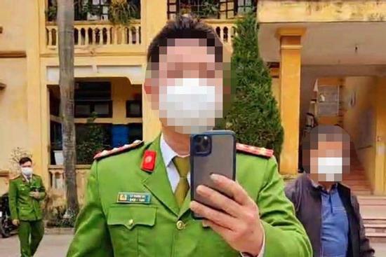 Công an 1 tay cầm điện thoại, 1 tay cầm súng nói chuyện với dân