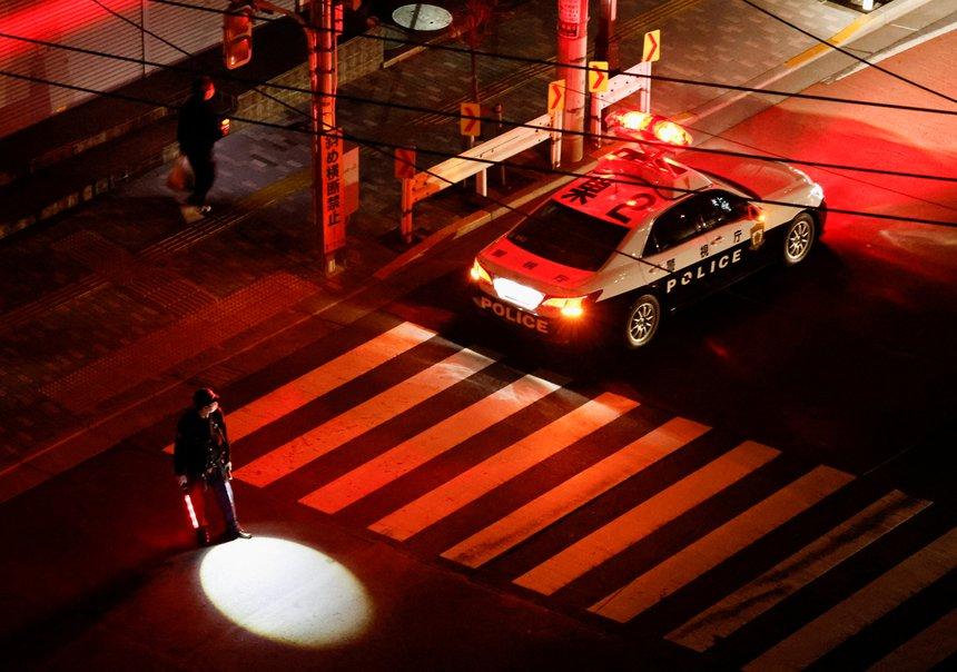 Một nhân viên cảnh sát điều tiết giao thông tại Tokyo khi đèn báo không hoạt động do mất điện.