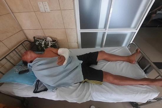 Ngồi trước cửa nhà, bị kề mã tấu vào cổ, chém gây thương tích