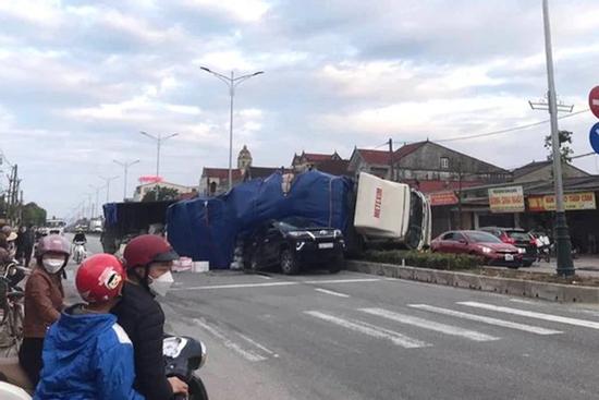 Dừng đèn đỏ, ô tô 7 chỗ bị xe tải tông rồi lật đè bẹp một phần