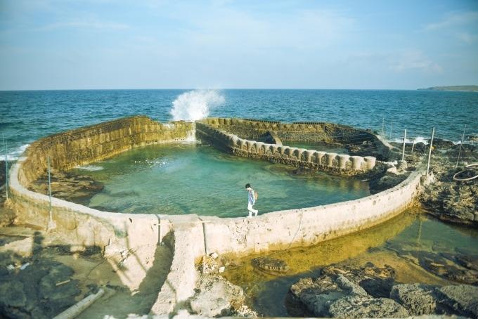 Hồ nuôi cá bỏ hoang phía sau dinh Mộ Thầy là điểm chụp ảnh lý tưởng, nổi tiếng tại Phú Quý. Bạn chịu khó đi ra phía xa, sóng biển vỗ ướt cả quần áo nhưng chắc chắn sẽ có những góc ảnh đẹp.