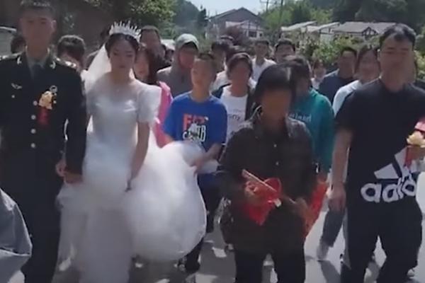 Fearing that her grandchild’s wedding would be maliciously disrupted, grandma took up arms as a bodyguard to lead the procession