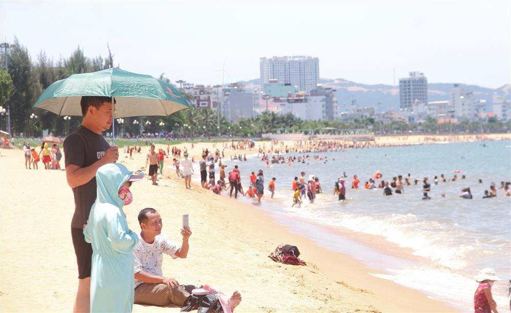The beach is crowded with people going down to bathe in the middle of the afternoon of the Lunar New Year-1