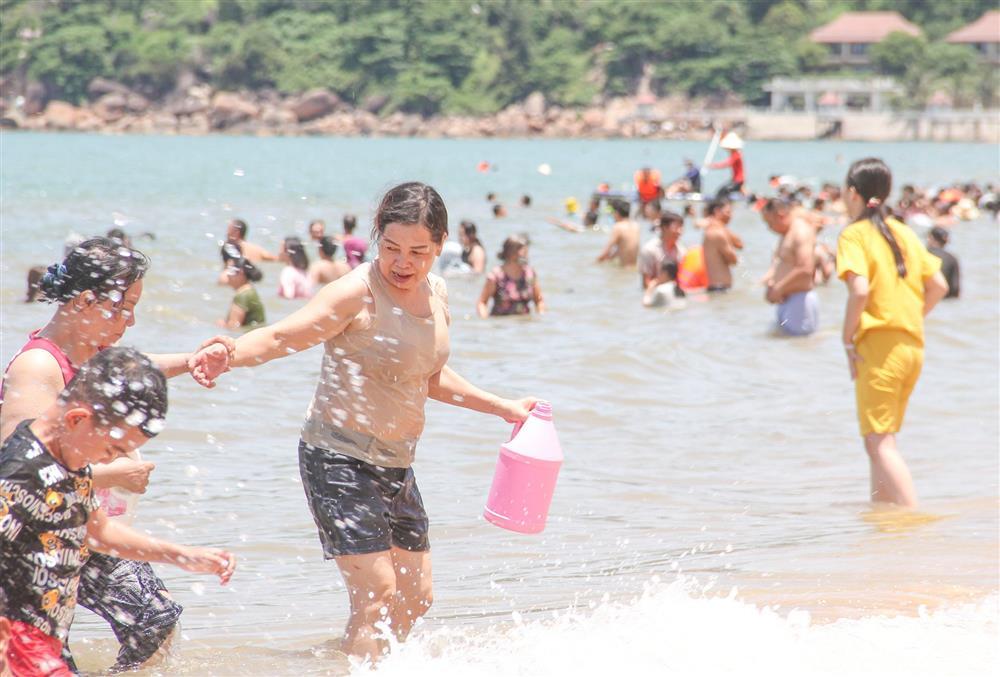 The beach is crowded with people going down to bathe in the middle of the afternoon of the Lunar New Year-3