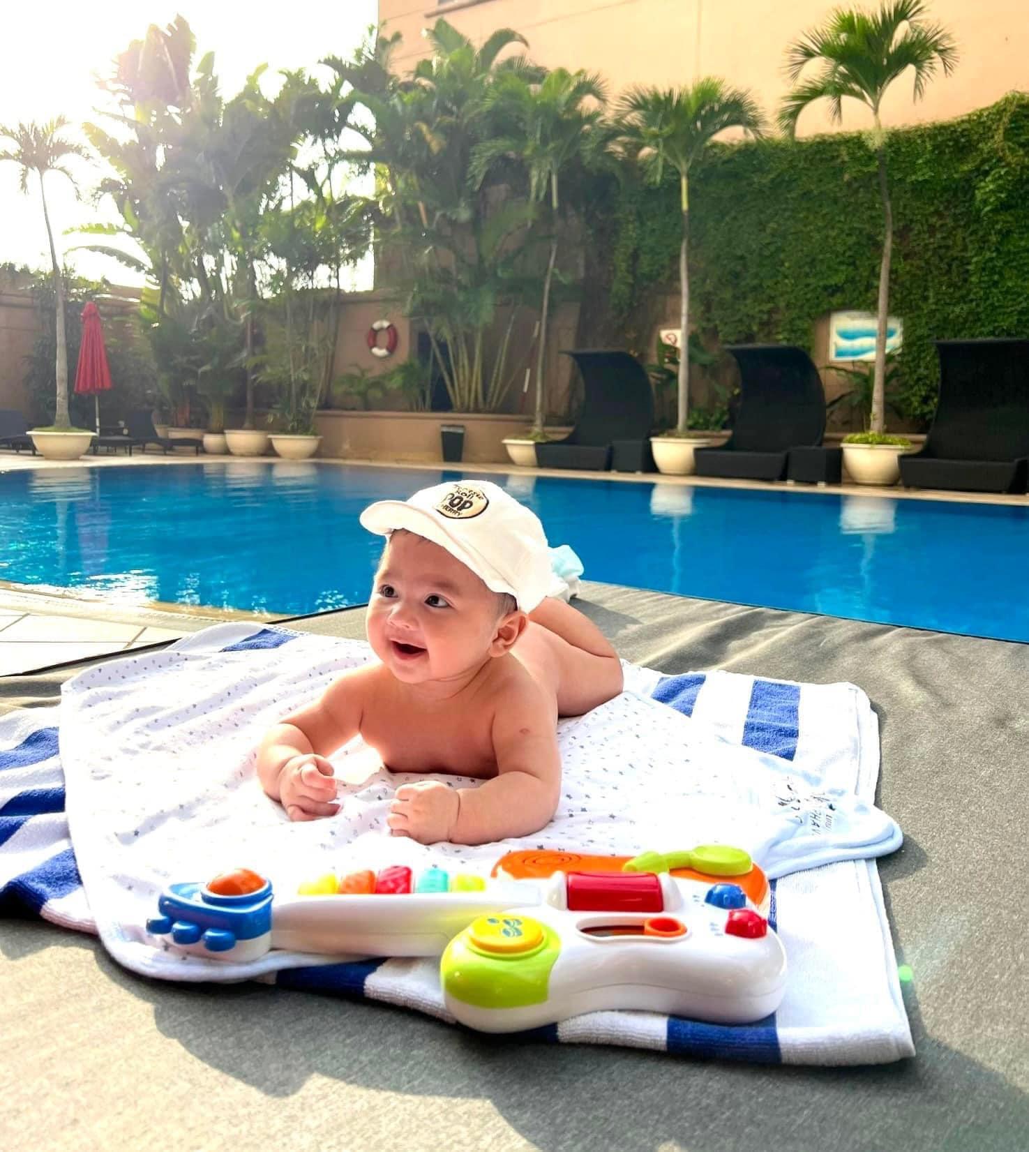 Lý Thùy Chang còn hài hước chia sẻ: "Khổ thân thằng bé sáng sớm còn mắt nhắm mắt mở đã bị mẹ bắt ra bơi hết mấy vòng hồ rồi chụp choẹt đủ kiểu, nhưng trộm vía cu cậu thấy máy ảnh là mắt lại sáng rỡ liền, từ nhỏ đã thích diễn giống mẹ rồi."