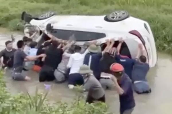 Giải cứu 2 cháu bé trong ô tô mất lái, lật ngửa dưới mương nước-1