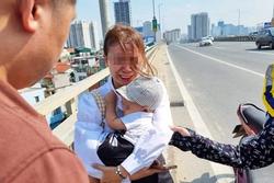 Người phụ nữ ôm con khóc trên cầu Nhật Tân