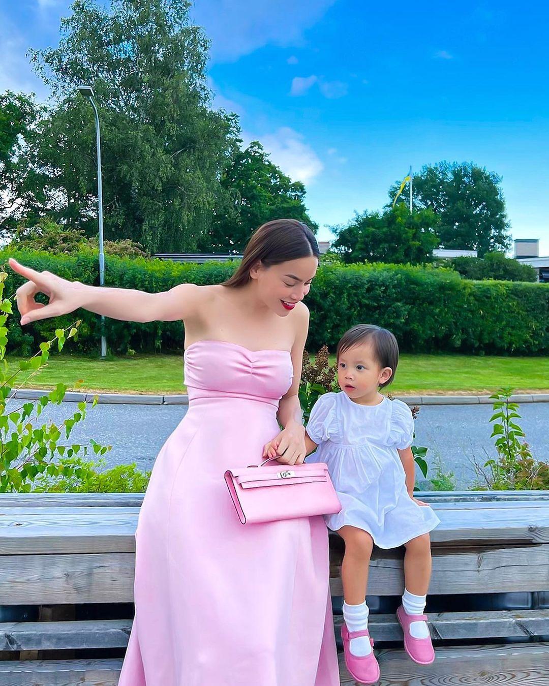 Lisa được mẹ diện váy trắng đi giày hồng đồng điệu với trang phục của cô. Hồ Ngọc Hà cũng được dịp làm điệu, khoe dáng đỉnh giữa không gian xanh mướt ở trời Tây.