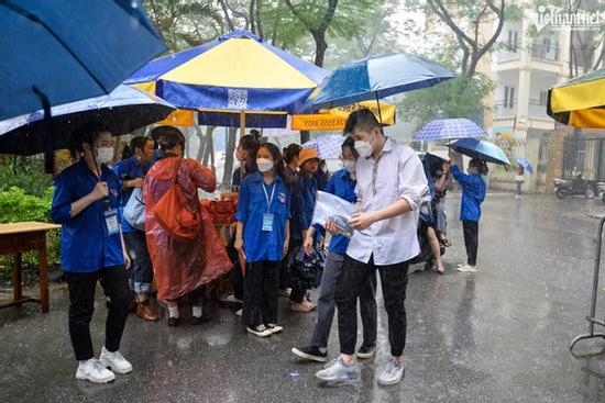 Thí sinh đến trường thi môn Toán trong cơn mưa