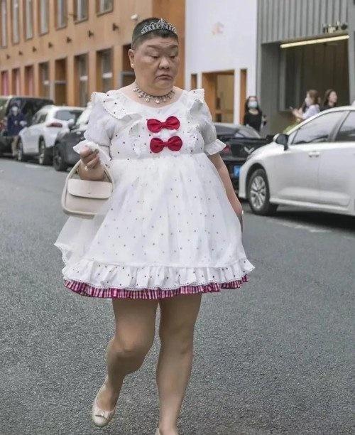 Người phụ nữ lớn tuổi mặc váy ngắn cũn sải bước trên phố-1