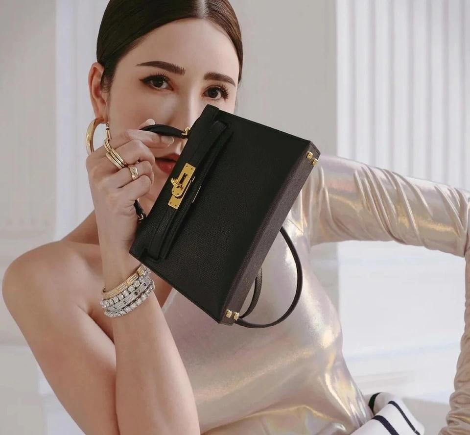 Túi Hermes Mini Kelly này có giá 11.200 đôla Singapore (8.055 USD). Nó là phiên bản 20 cm của mẫu Hermes Kelly được yêu thích cuồng nhiệt. Mẫu túi mini có số lượng rất ít. Mini Kelly có nhiều tùy chọn da cổ điển, bao gồm epsom, da bê cứng và chèvre. Chiếc túi có phần cứng mạ vàng và palladium.