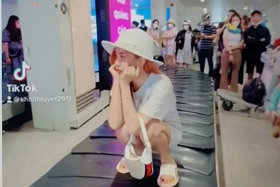 Xác minh nữ hành khách ngồi trên băng chuyền chờ hành lý ở sân bay