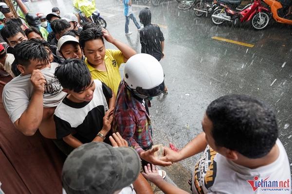 Dù bên ngoài trời mưa to, vẫn có nhiều người đổ về để nhận tiền cúng của chủ nhà.