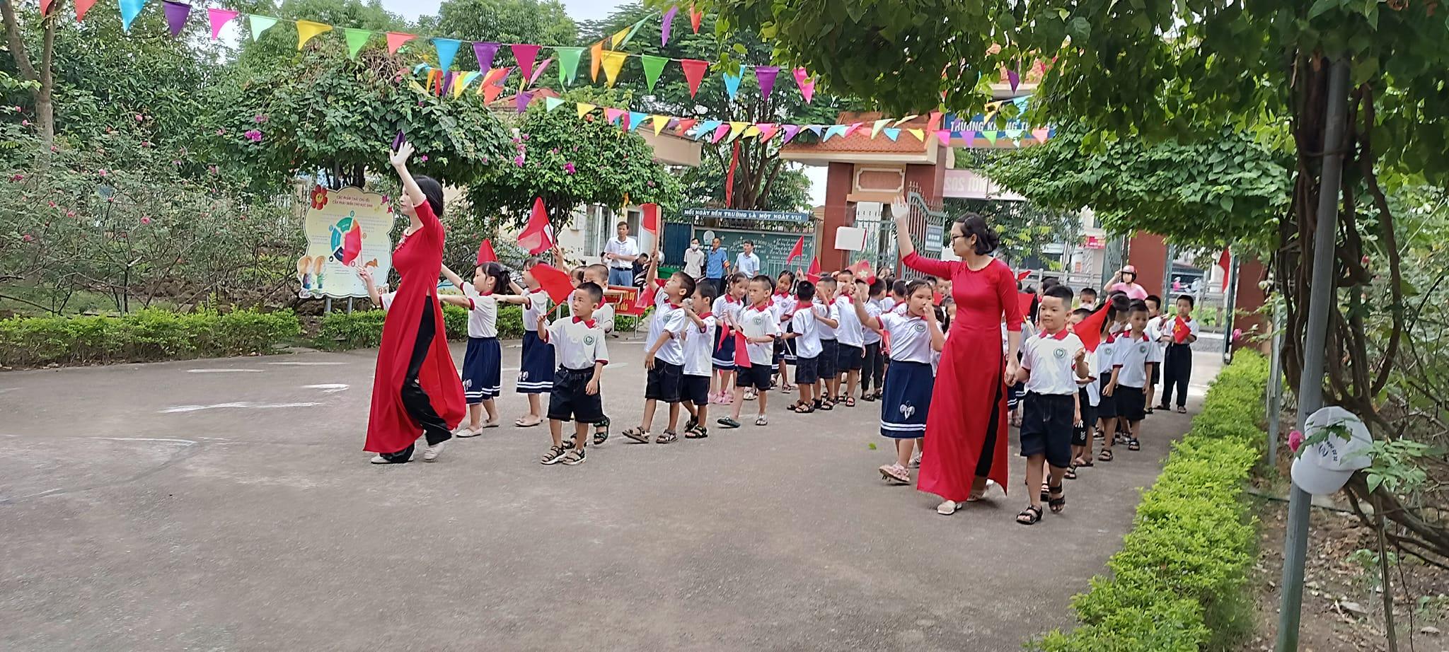 Các em học sinh lớp 1 tại một trường ở Nam Định được thầy cô dẫn vào khai giảng