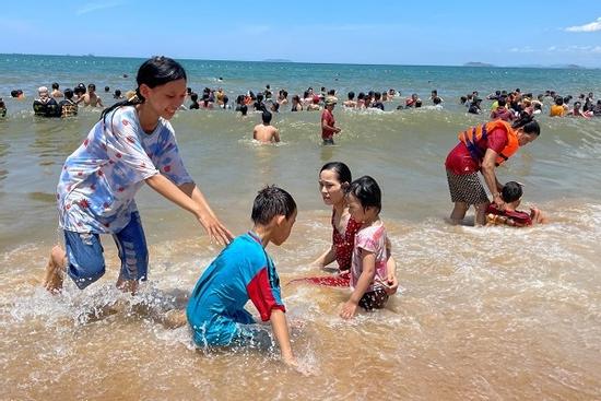 Tết Đoan Ngọ, đúng 12h trưa người 'xứ Nẫu' mặc áo chống nắng, che ô tắm biển xả xui