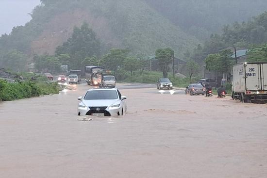 Quốc lộ 6 ngập như sông, xe máy bị cuốn trôi