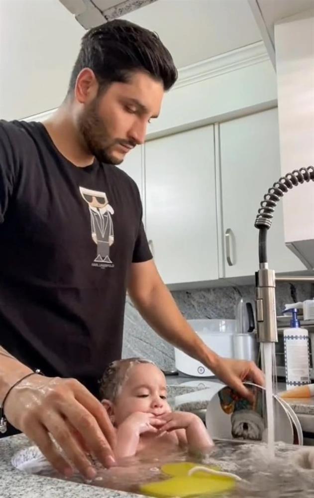 Dân mạng mắng tơi tả ông bố tắm cho con trong bồn rửa đầy chén đĩa bẩn-1