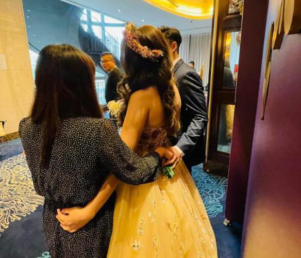 Bạn thân cô dâu nắm tay chú rể sau lưng khi cùng chụp ảnh tại đám cưới-1