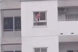 Hãi hùng cảnh bé trai vắt vẻo trên thành cửa sổ tầng cao chung cư