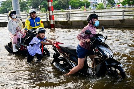 Triều cường lên đỉnh, người dân chật vật lội nước về nhà, nấu cơm bằng bếp dầu